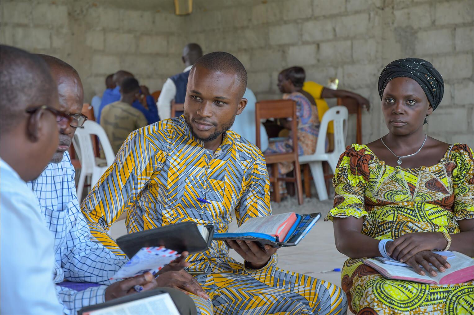 Participants en petit groupe d'étude, bibles ouvertes, lors d'une formation de l'École du Ministère